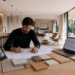 Interiorista planificando una reforma integral con planos, muestras de materiales y diseño de una vivienda moderna.